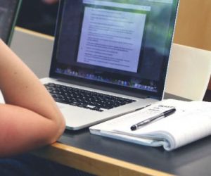 Imagem de uma pessoa estudando cm um notebook e um livro
